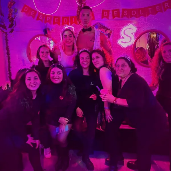 Grupo de despedida de soltera posando con un vedetto en el Club de Princesas